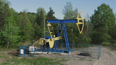 aerial orbit around oil pumpjack pumping crude oil near campina, romania