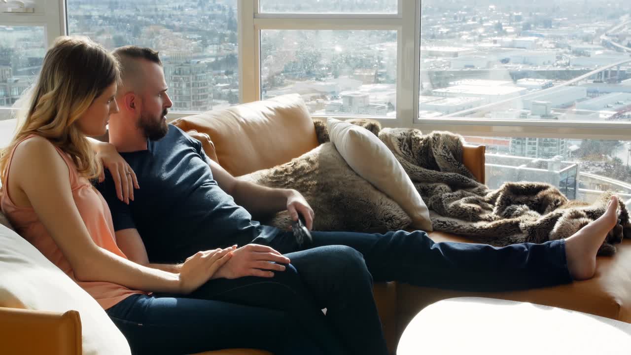 Couple watching television together in living room 4k