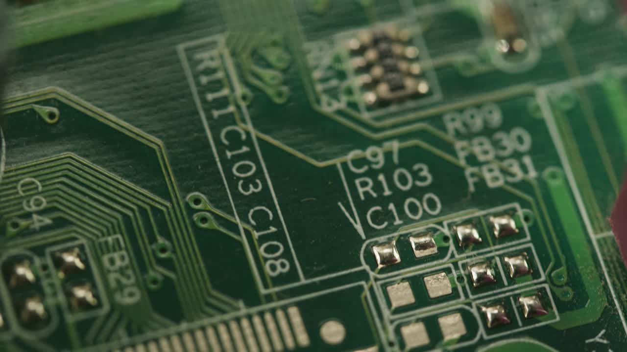 Close-up Macro Pan of a Green Circuit Board with Microchips