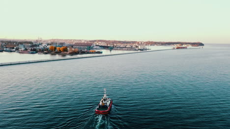 drone flying over the fishing boat sailing on the baltic sea at the sunset in gdynia