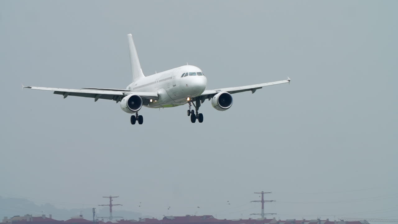 Aereo passeggeri bianco in avvicinamento per l'atterraggio con il carrello di atterraggio abbassato