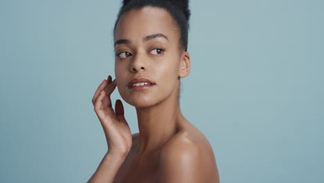 portrait-healthy-young-woman-touching-face-with-hand-caressing-smooth-skin-complexion-enjoying-soft-natural-beauty-on-blue-background-skincare-concept