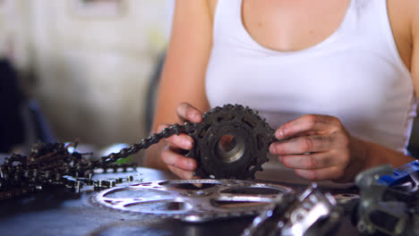 Woman-repairing-parts-of-bicycle-at-workshop-4k