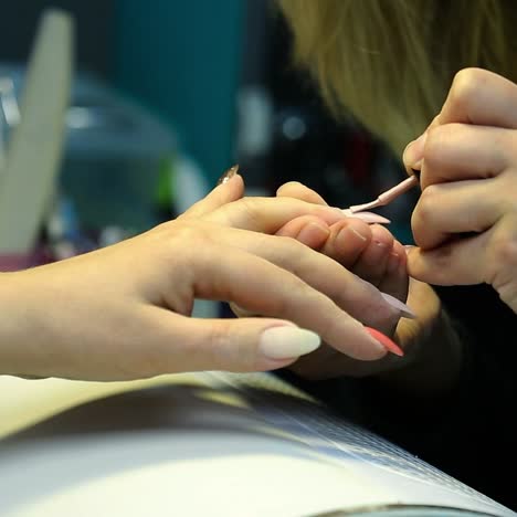 una mujer haciendo una manicura de uñas.