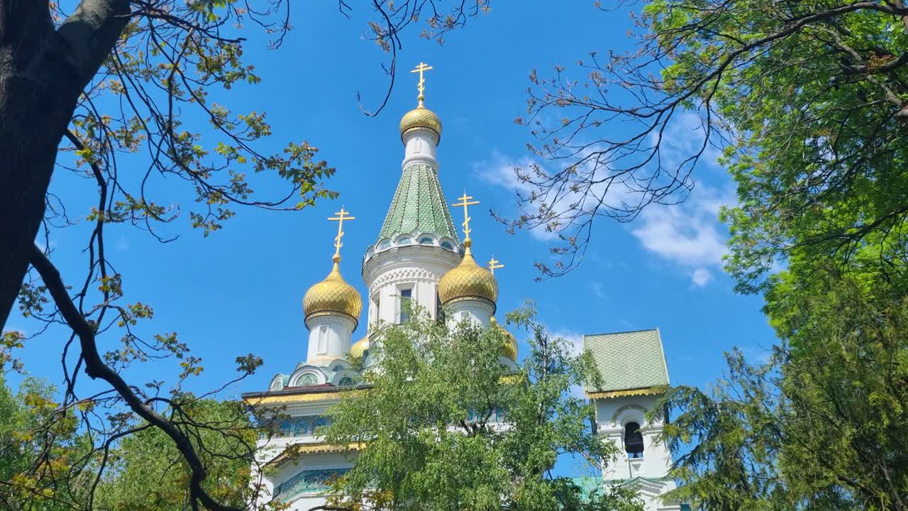 Picturesque shot of the Church of St. Nicholas the Miracle-Maker in central Sofia, Bulgaria, on a bright and sunny spring day, surrounded by vibrant green foliage