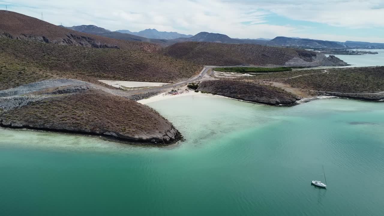플라야 엘 테콜로테 (playa el tecolote) 의 화려한 해안 앞에서 촬영된 공중 돌리. 푸른 바 ⁇ 물, 건조한 여름 풍경 및 멕시코 바야 캘리포니아 서르 근처의 원시 해변