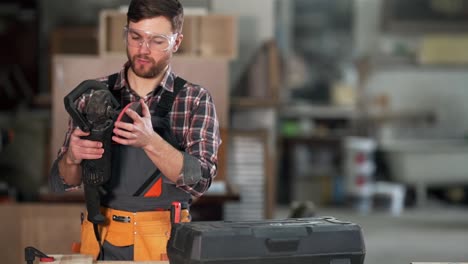 young male carpenter puts on a grinding wheel