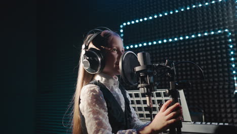 una joven cantando en un estudio de grabación