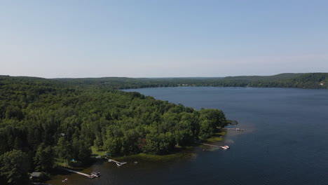 aerial pedestal above private docks at forested lake shore on sunny blue sky day