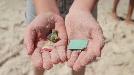 Volunteer-girl-holding-waste-in-her-hands-on-the-beach-4k