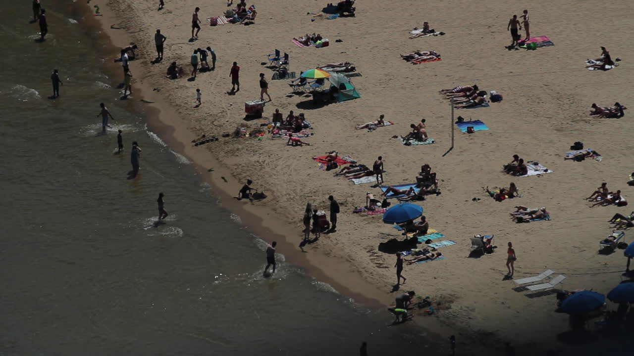 Aerial view of a crowded beach with people enjoying the sun and water
