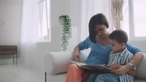 Madre-Sentada-Con-Su-Hijo-Leyendo-Un-Cuento-En-El-Interior