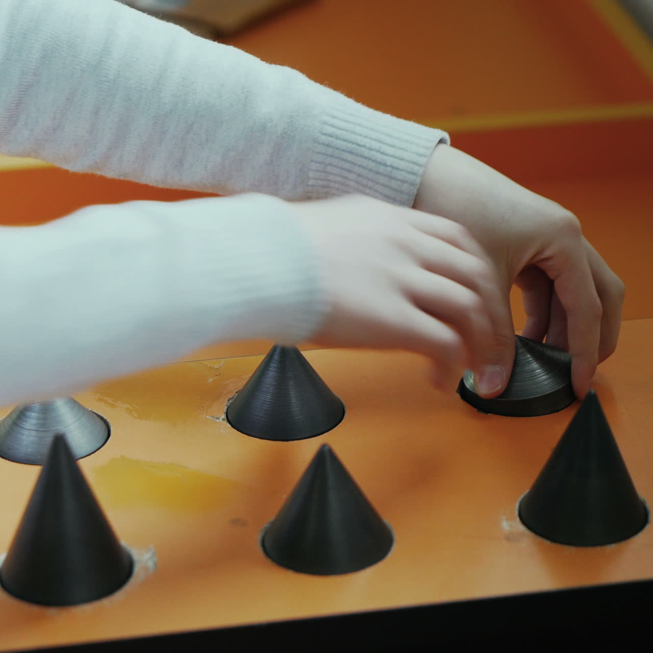 Boy is trying to pick up the metal cones. Museum of entertaining sciences. Concept of physics Square video