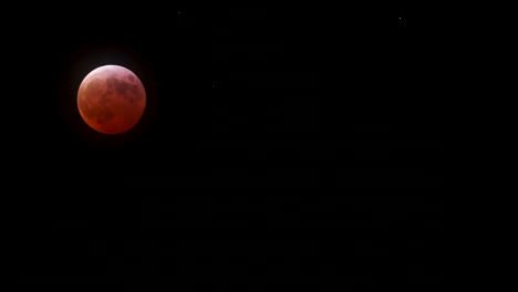 timelapse of the total lunar eclipse on march 14th, 2025, red blood moon passes behind thin clouds