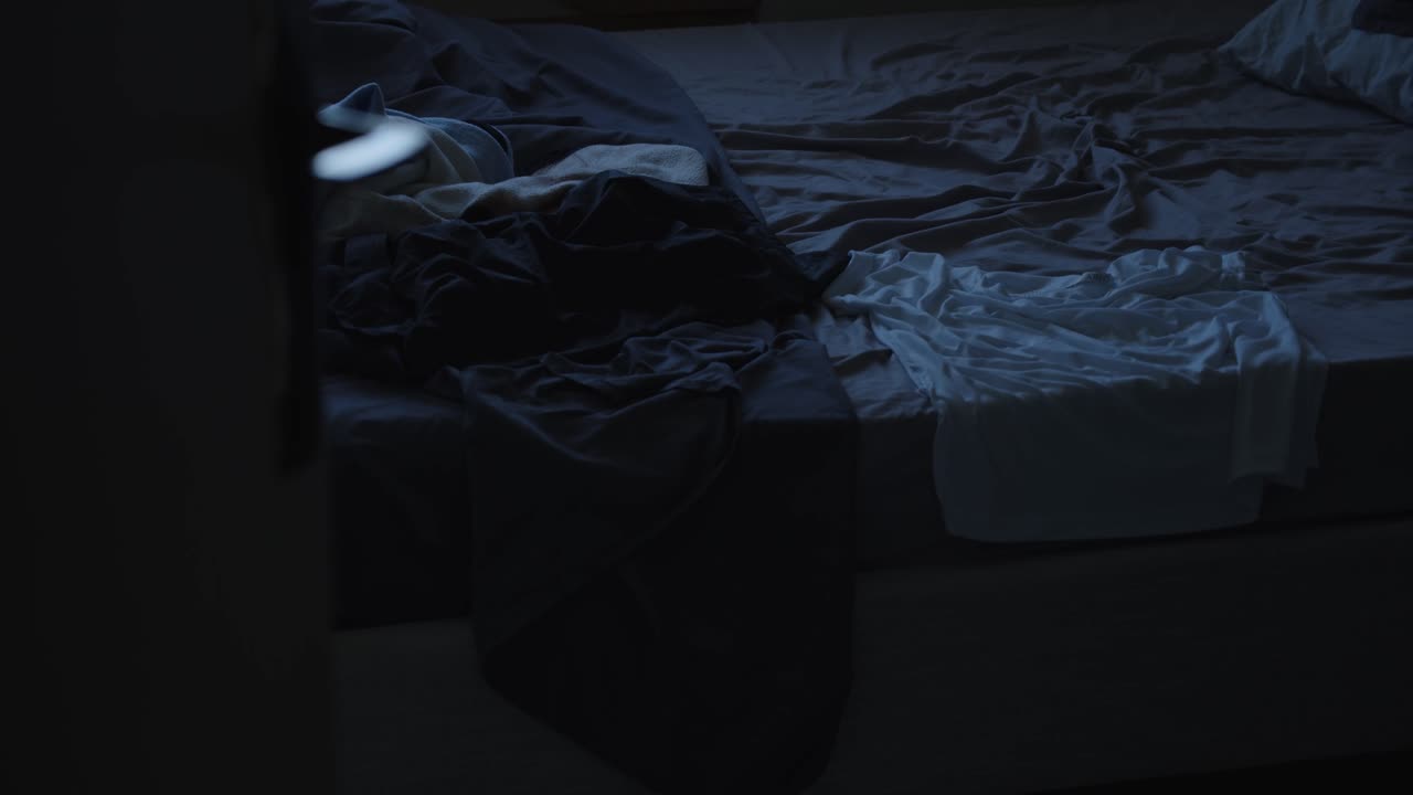 Lit en désordre laissé après s'être levé tôt le matin, vue en mouvement.