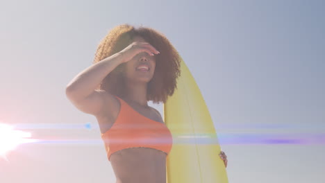 animación de luces sobre una mujer afroamericana que sostiene una tabla de surf