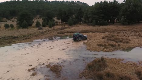 coche todoterreno cruzando un charco de agua en acción