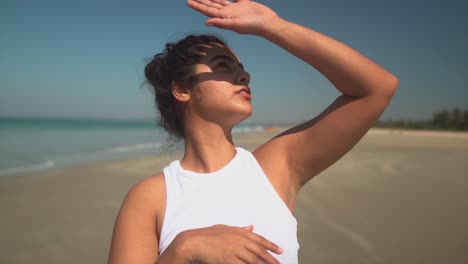 beautiful girl hiding her face and eyes from the sun while looking into the sky