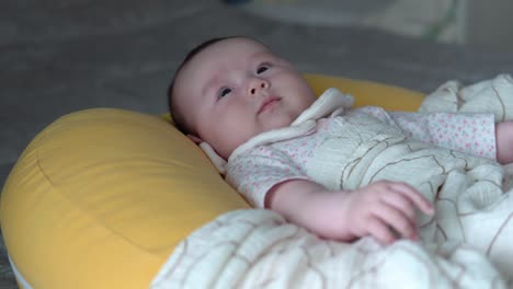 Süßes-Kleines-Baby,-Das-Auf-Gelbem-Rototo-Kissen-Liegt,-Das-Mit-Einer-Decke-Bedeckt-Ist