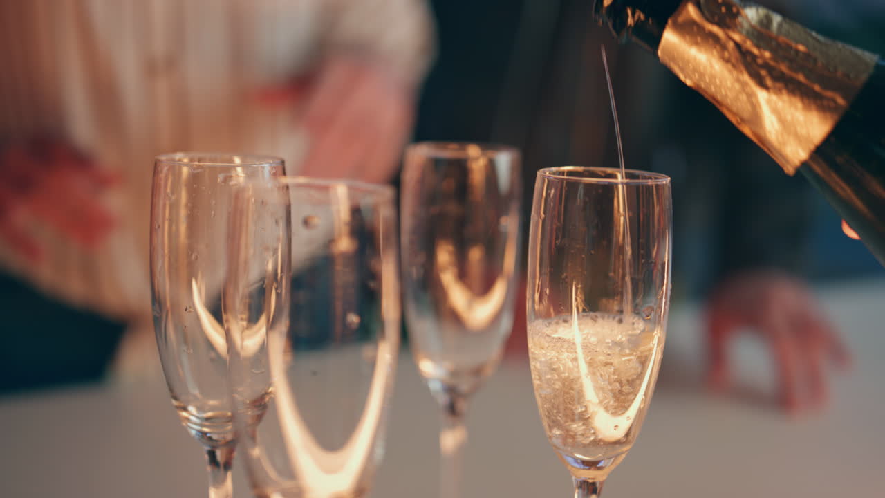 클로즈업 웨이터 손이 술집 카운터에서 와인 글래스를 부어. 바텐더가 병을 들고