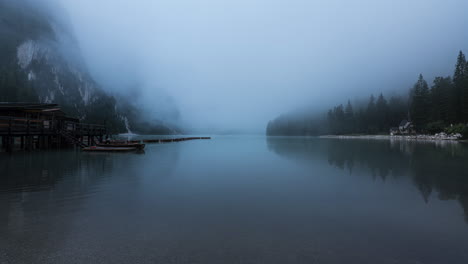 misty weather over lake near dolomite mountains, time lapse