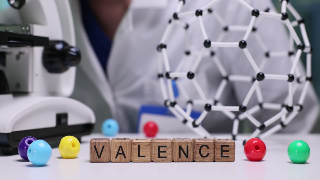 La parola 'Valenza' composta con blocchi di legno in un laboratorio scientifico.