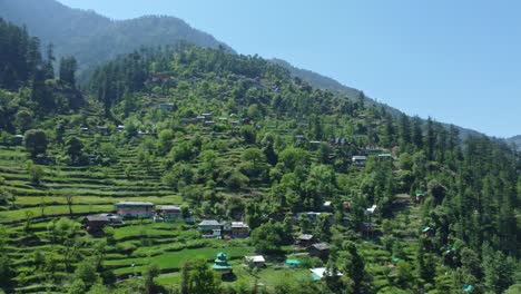 aerial view short of jibhi himachal pradesh in india. houses and trees in the mountainous area. faguli festival is one of the biggest festival in jibhi. the traditional houses here have stone roofs.