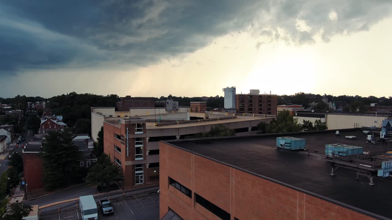 Tomada aérea ascendente de uma tempestade assustadora trazendo chuva, vento, trovões e raios sobre o cenário urbano da cidade de Lancaster, Pensilvânia.