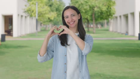 happy indian girl showing heart sign