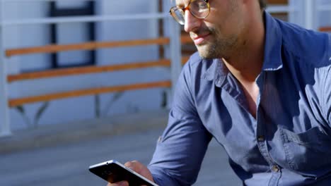 Man-using-mobile-phone-in-the-porch-4k