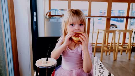 Niña-Comiendo-Hamburguesa-En-El-Restaurante-De-Comida-Rápida,-Cámara-Lenta