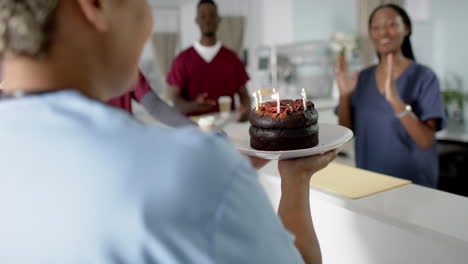 diversos médicos masculinos y femeninos celebrando su cumpleaños en la recepción del hospital, en cámara lenta