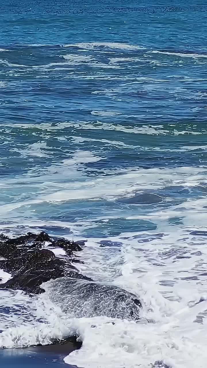 Onde che si infrangono sulla costa rocciosa cilena durante l'estate.