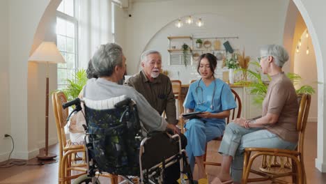 happiness cheerful elderly woman and men talking with female caregiver nurse doctor having health checking consult at living area,caretakers with senior couple sitting in living room at nursing home