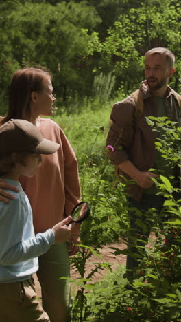 family exploring nature with magnifying glass