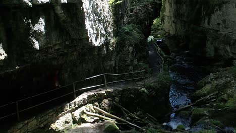 vista aérea del sendero dentro de una cueva del cañón, gente caminando sendero peligroso, suiza