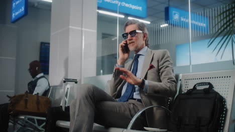 businessman talking on phone at airport security checkpoint
