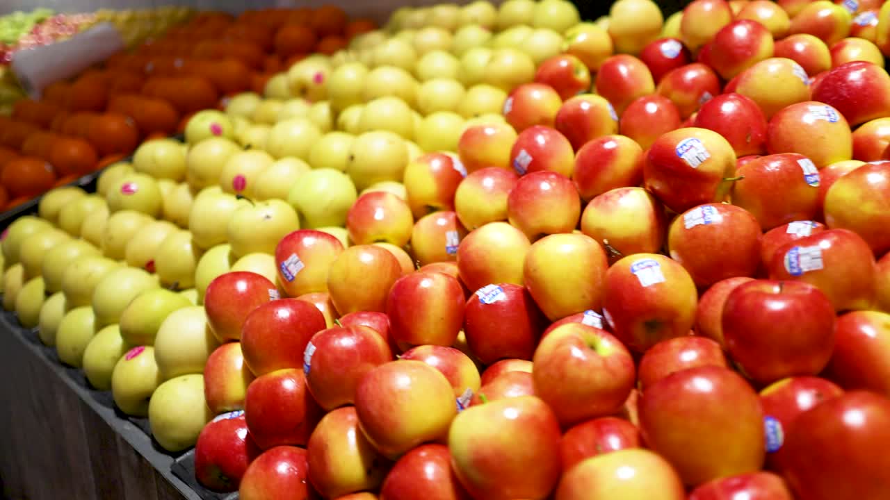 Colorful arrangement of fruits in a Gold Coast supermarket. Bright lighting highlights apples, oranges, and pears in neat rows
