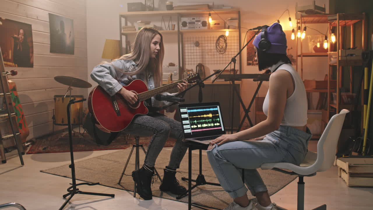 Female Guitarist Recording Music On Acoustic Guitar