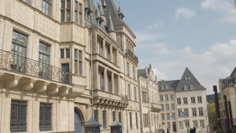 Pan-Del-Edificio-Monumental-A-La-Gente-Caminando-Por-La-Calle-En-El-Centro-De-Luxemburgo