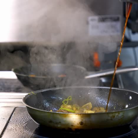 professional chef is cooking mushrooms. cook is preparing mushrooms in a frying pan and pouring sauce on them. delicious food in a restaurant