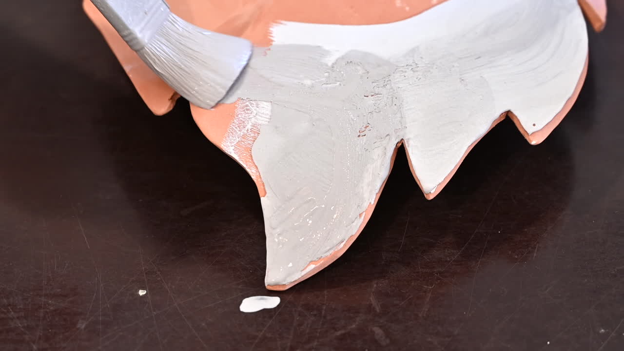 Woman painting the bottom of a leaf plate with white