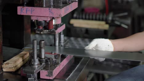 the machine is working by stamping a circle from a long steel plate, controlled by the worker.