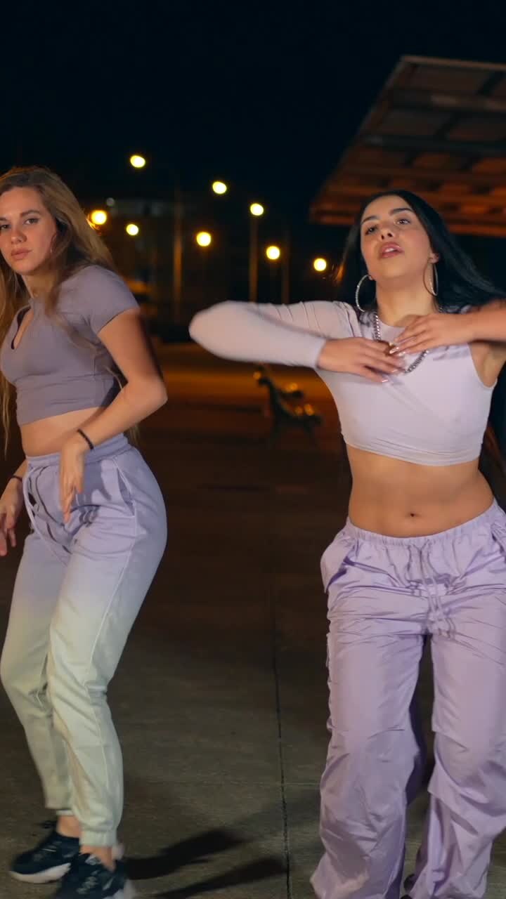 Group of young women dancing in the street at night