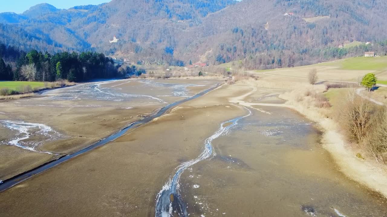 Aerial: Dolly in flight near Savinja river above Savinja Valley, towards Zovnek Castle, Podvrh village and mountainous landscape