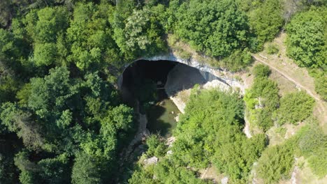 river and gods bridge cave surrounded by green forest near vratsa, bulgaria