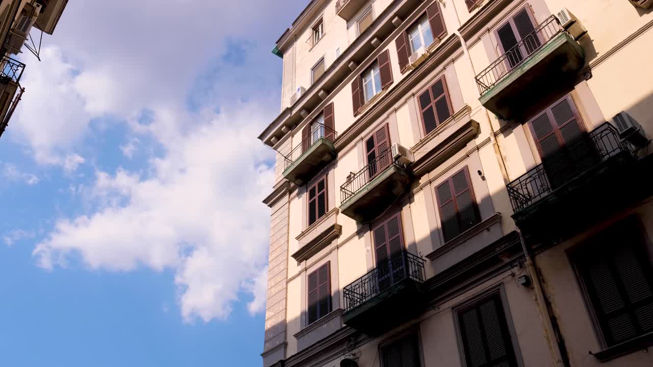 Slow Wide Tracking Shot of Shaded Neapolitan Building with Deep Blue Skies Behind