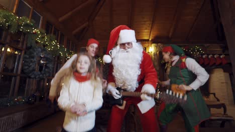 happy santa clause with children. santa clause dancing with children and elves