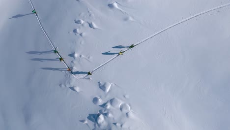 Antena-De-Arriba-Hacia-Abajo-Que-Muestra-Un-Grupo-De-Escaladores-De-Montaña-Esquí-De-Montaña-Montaña-Nevada-En-Italia