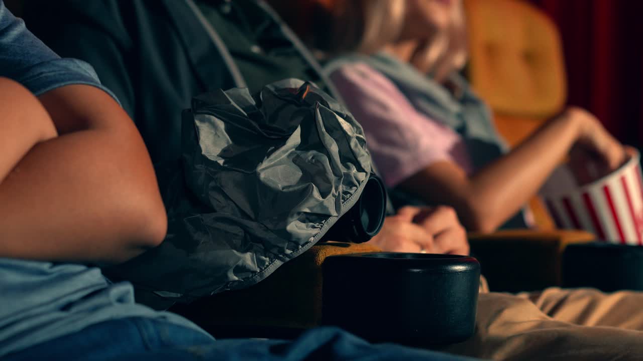 un hombre está filmando un video en secreto mientras ve una película.